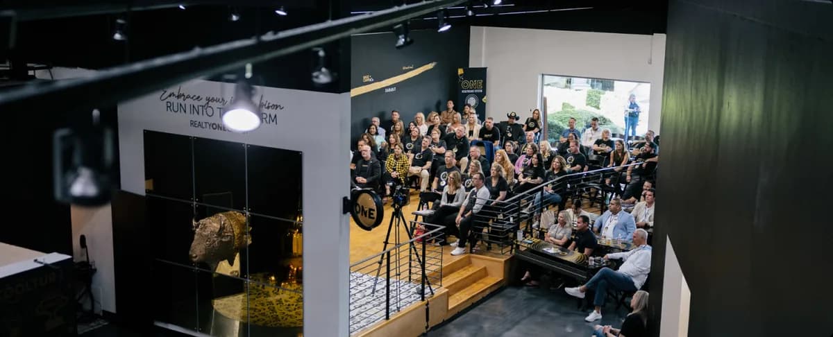 A Realty ONE Group audience gathered in the COOLTURE room around the golden bison