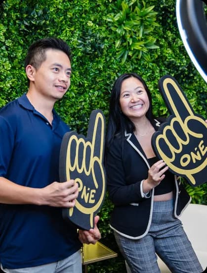 Two brokers holding ONE foam fingers
