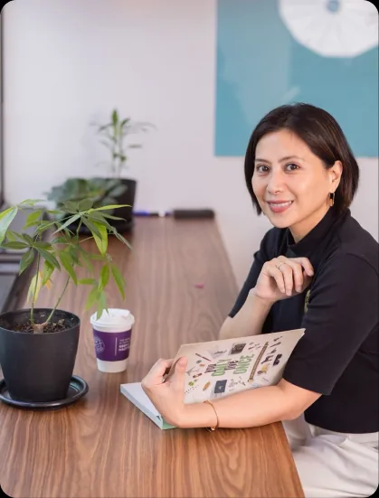 A broker at her desk with a Realty ONE Group magazine