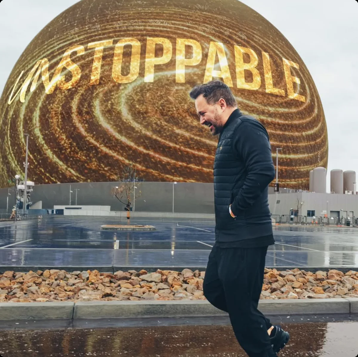 Kuba Jewgieniew walking past the Sphere lit with the word UNSTOPPABLE